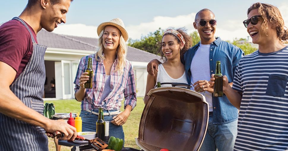 5 friends enjoying time together around a bbq with drinks