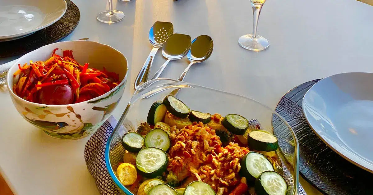 A table set with various dishes and drinks, showcasing a colorful and inviting meal arrangement.