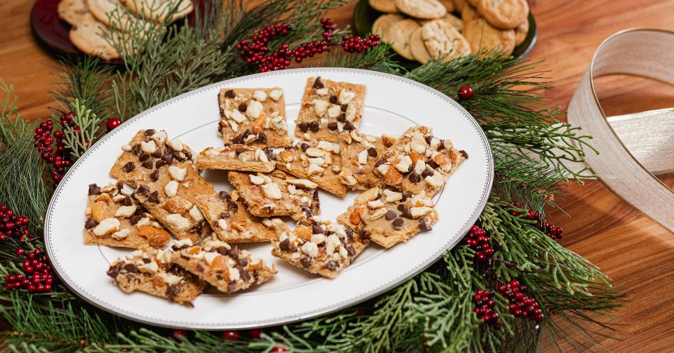 Pretzel Heath Cookies organized on a white oval plate and placed on a festive wreath with ribbon and other cookies on the edges