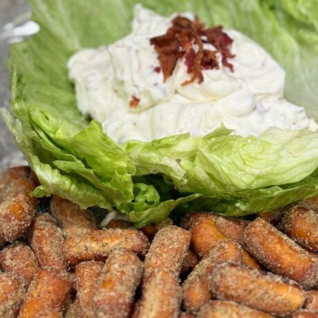 White BLT dip on a bed of lettuce with bacon bits on top and OMG! Garlic Pretzels on the side