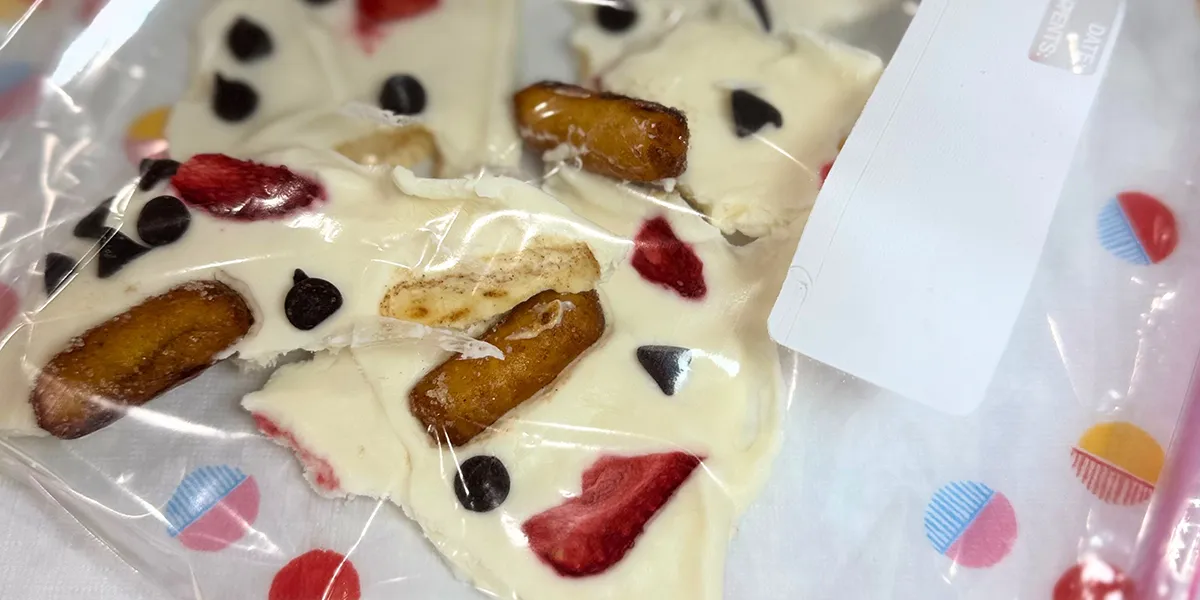 White chocolate-covered strawberries and bananas arranged on a plate, showcasing a delicious dessert option.