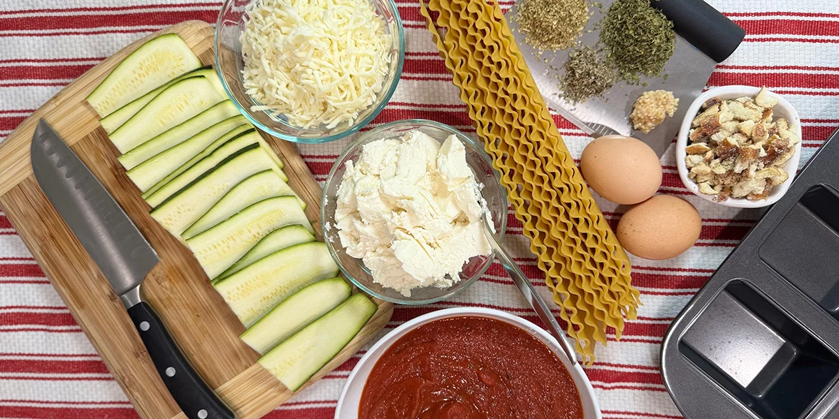 A table filled with various cooking ingredients, including vegetables, spices, and utensils, ready for meal preparation.