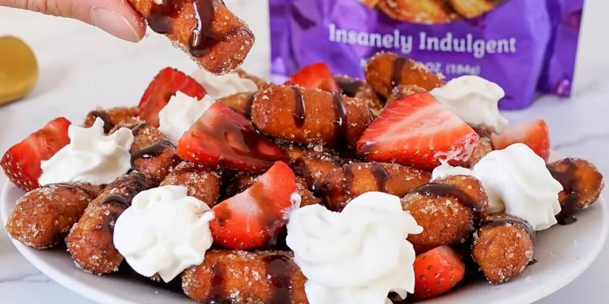A plate of fresh strawberries topped with fluffy whipped cream, elegantly arranged for a delightful dessert presentation.