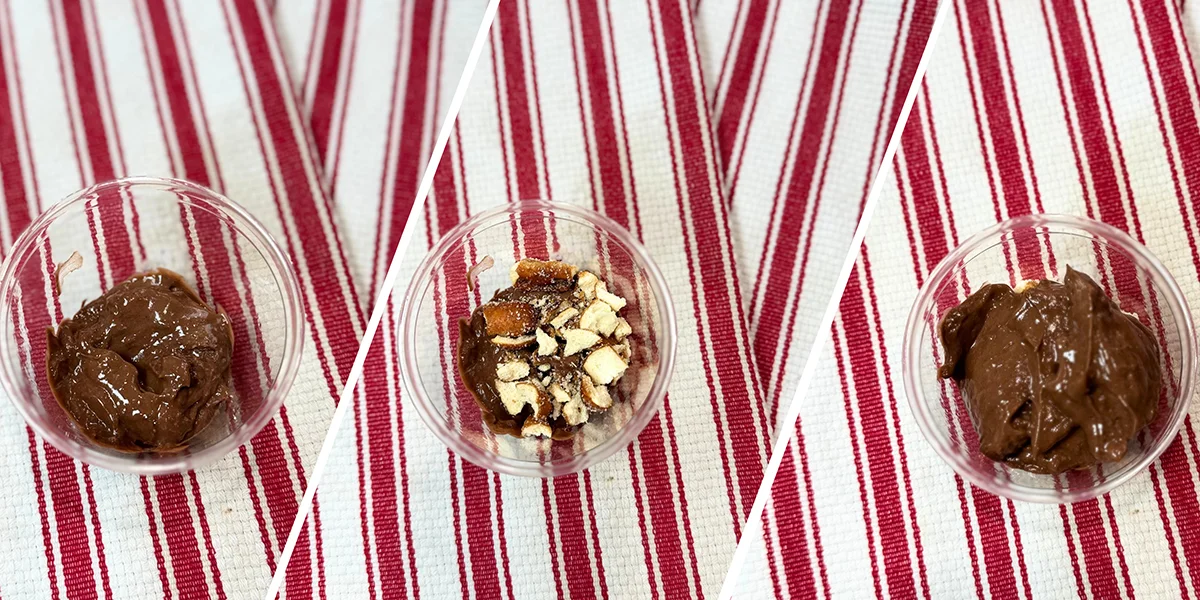 Three-step dessert preparation displayed. First, chocolate pudding in a glass cup, then topped with crushed cookies, and finished with a final pudding layer. Set on a red and white striped cloth.